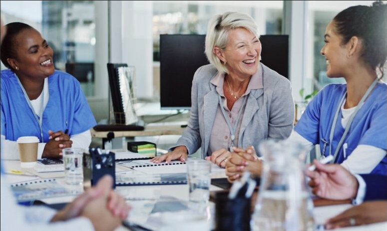 Three people, including two clinicians sitting together in a meeting